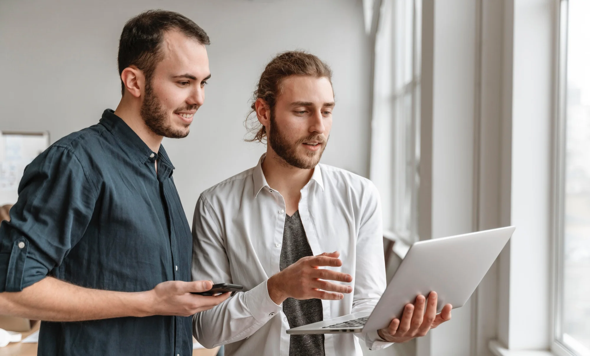 Deux collaborateurs analysant des informations sur ordinateur dans le cadre d'un projet de communication